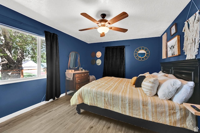 2890 Wheelock Ave, Ogden, UT 84403 - bedroom featuring wood finished floors, a textured ceiling, baseboards, and a ceiling fan