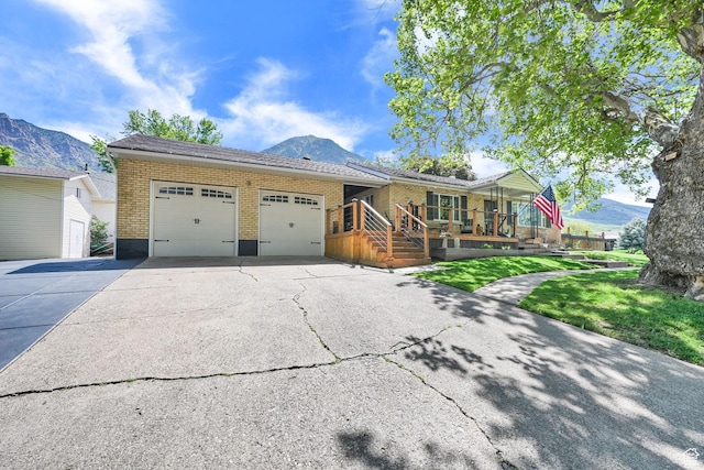 2890 Wheelock Ave, Ogden, UT 84403 - ranch-style home with an attached garage, a mountain view, brick siding, and driveway