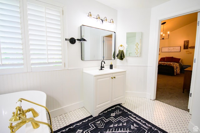2763 N Hills Dr, Layton, UT 84040 - ensuite bathroom with a wainscoted wall, vanity, a freestanding tub, and tile patterned floors