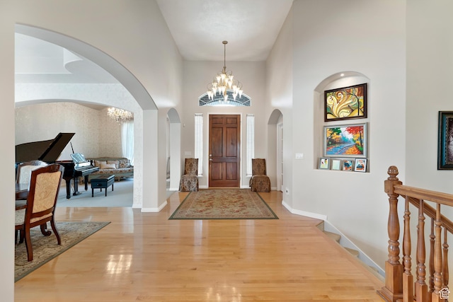 531 W Glendon Way, Pleasant Grove, UT 84062 - foyer featuring a chandelier, arched walkways, light wood finished floors, a towering ceiling, and baseboards