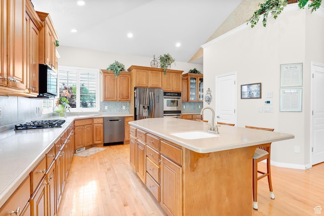 531 W Glendon Way, Pleasant Grove, UT 84062 - kitchen with stainless steel appliances, a sink, light wood finished floors, a breakfast bar, and a center island with sink