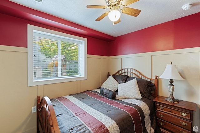 1516 N Willow Valley Dr W, Centerville, UT 84014 - bedroom with wainscoting, a ceiling fan, and a decorative wall