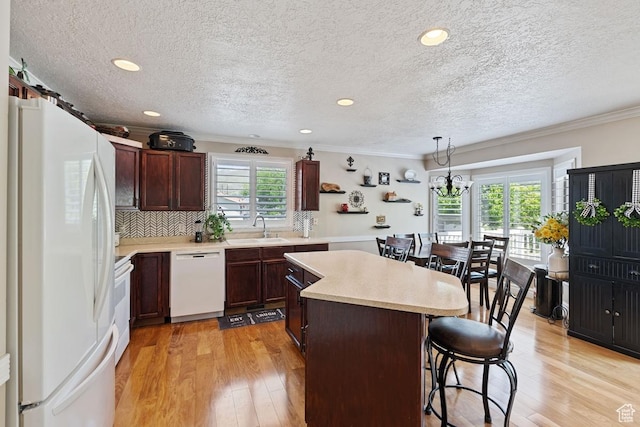 1516 N Willow Valley Dr W, Centerville, UT 84014 - kitchen with white appliances, a sink, a center island, a breakfast bar, and ornamental molding