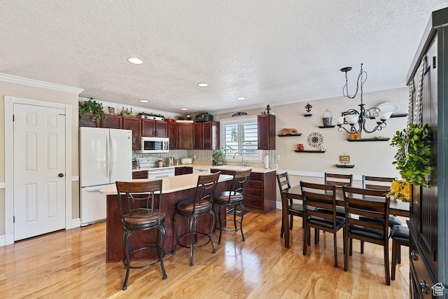 1516 N Willow Valley Dr W, Centerville, UT 84014 - kitchen featuring white appliances, a textured ceiling, light countertops, light wood-style flooring, and ornamental molding