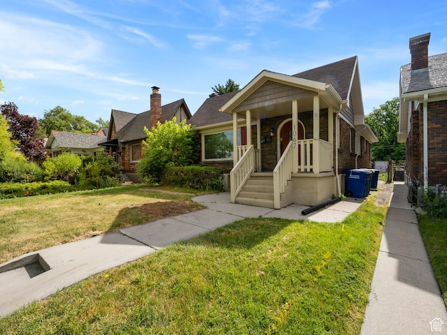 1067 S 400 E, Salt Lake City, UT 84111 - bungalow-style house featuring a front yard, brick siding, a chimney, and a shingled roof