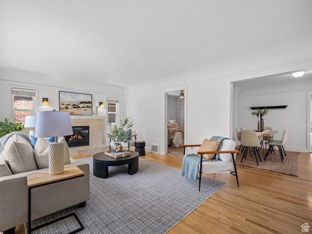 1067 S 400 E, Salt Lake City, UT 84111 - living area with a textured ceiling, light wood-style flooring, and a tile fireplace