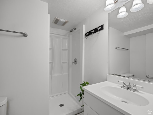 1067 S 400 E, Salt Lake City, UT 84111 - bathroom featuring a stall shower, a textured ceiling, and vanity