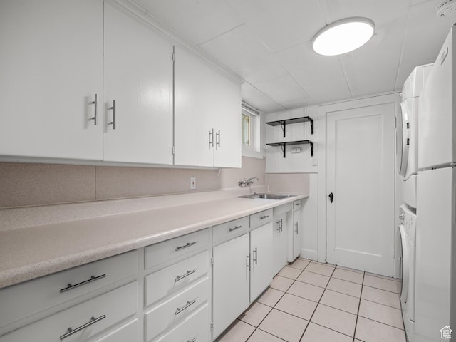 1067 S 400 E, Salt Lake City, UT 84111 - kitchen featuring stacked washer / dryer, light tile patterned floors, light countertops, and white cabinets