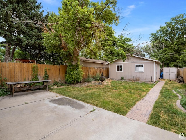 1067 S 400 E, Salt Lake City, UT 84111 - fenced backyard featuring a patio area, a storage unit, a detached carport, and driveway
