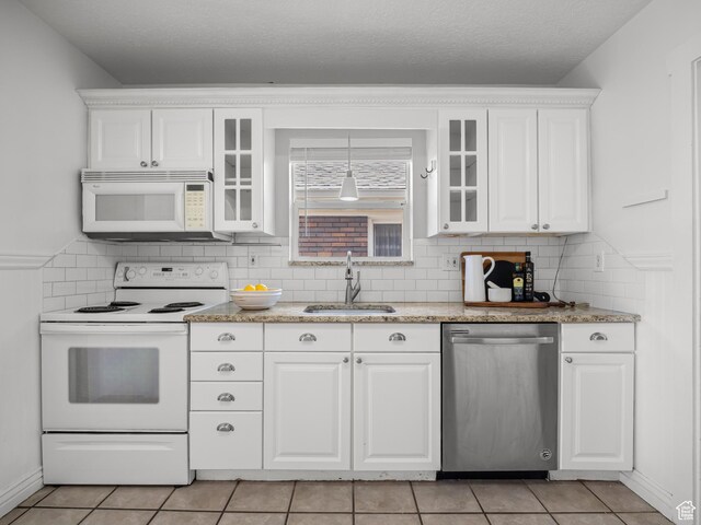 1067 S 400 E, Salt Lake City, UT 84111 - kitchen with white appliances, white cabinets, glass insert cabinets, and decorative backsplash