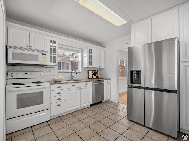 1067 S 400 E, Salt Lake City, UT 84111 - kitchen with appliances with stainless steel finishes, white cabinets, glass insert cabinets, and backsplash