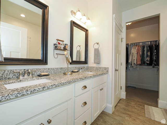 104 S Summer Breeze Ln W, Layton, UT 84041 - bathroom featuring wood finished floors, a spacious closet, double vanity, baseboards, and recessed lighting
