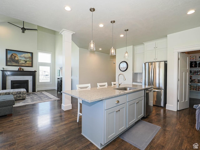 104 S Summer Breeze Ln W, Layton, UT 84041 - kitchen with a sink, stainless steel appliances, open floor plan, light stone countertops, and a glass covered fireplace