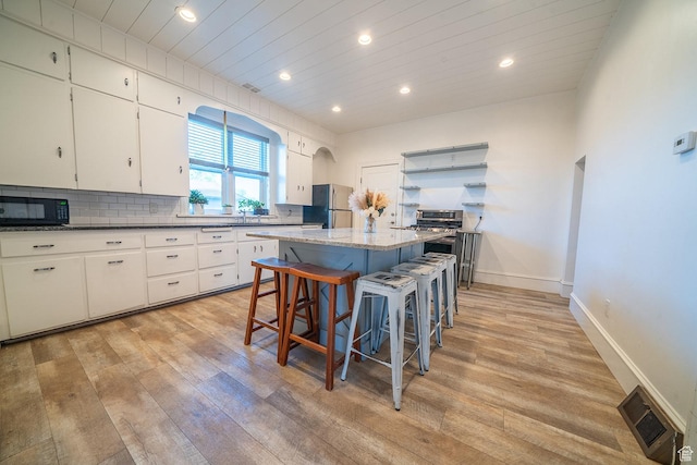 59 E 300 N, Ephraim, UT 84627 - kitchen with stainless steel appliances, light wood finished floors, a center island, recessed lighting, and a breakfast bar area