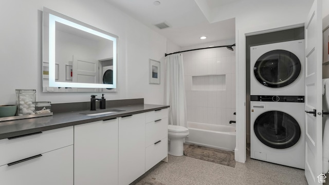 14708 S Woods Landing Ct E, Draper, UT 84020 - full bathroom featuring stacked washer and clothes dryer, speckled floor, toilet, shower / tub combo with curtain, and vanity