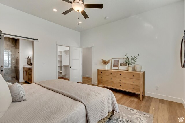 864 S 1260 W Unit 129, Heber City, UT 84032 - bedroom with baseboards, light wood-style floors, a barn door, a walk in closet, and ensuite bathroom