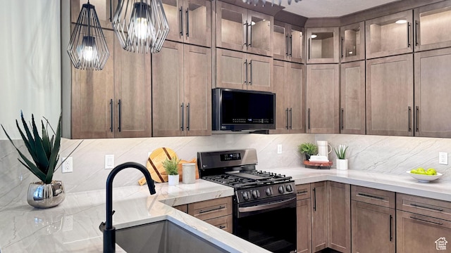 864 S 1260 W Unit 129, Heber City, UT 84032 - kitchen with stainless steel range with gas cooktop, decorative backsplash, a sink, glass insert cabinets, and decorative light fixtures