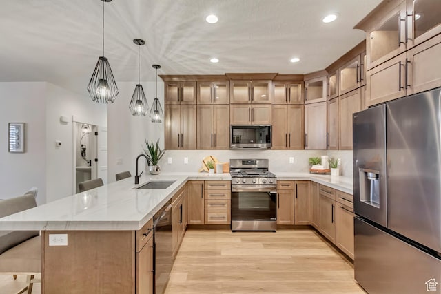 864 S 1260 W Unit 129, Heber City, UT 84032 - kitchen with appliances with stainless steel finishes, a sink, a peninsula, light wood-style flooring, and a breakfast bar