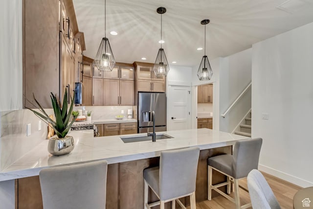 864 S 1260 W Unit 129, Heber City, UT 84032 - kitchen featuring stainless steel fridge, a peninsula, light stone counters, baseboards, and decorative backsplash