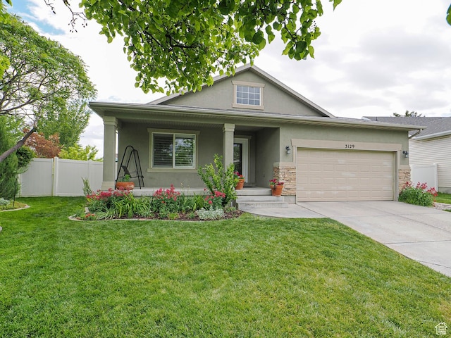 3129 S Eagle Rock Way W, West Valley City, UT 84120 - view of front of home featuring stucco siding, a porch, driveway, an attached garage, and stone siding