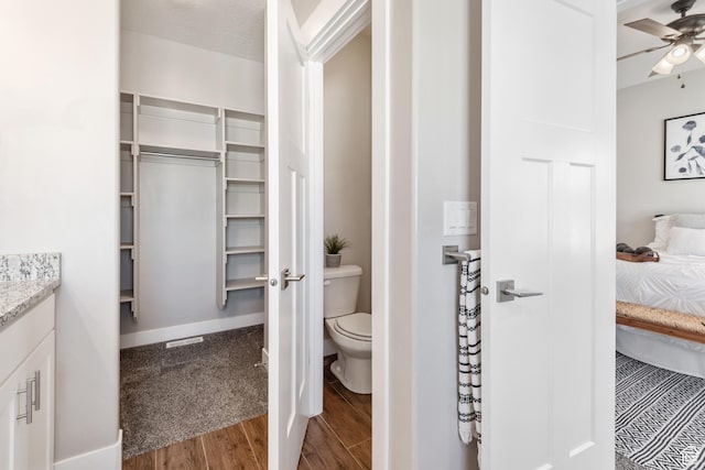 4957 N Sage Dr, Eagle Mountain, UT 84005 - full bathroom with wood finished floors, ceiling fan, toilet, ensuite bathroom, and vanity