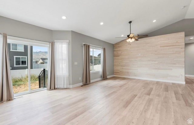 4957 N Sage Dr, Eagle Mountain, UT 84005 - unfurnished living room with vaulted ceiling, plenty of natural light, ceiling fan, wood walls, and an accent wall
