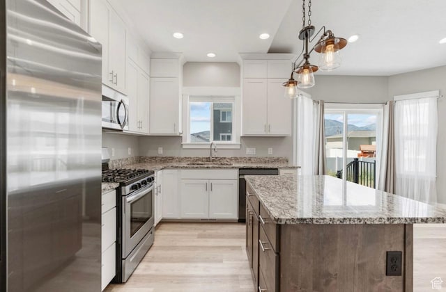 4957 N Sage Dr, Eagle Mountain, UT 84005 - kitchen featuring stainless steel appliances, light wood-style floors, a kitchen island, plenty of natural light, and recessed lighting