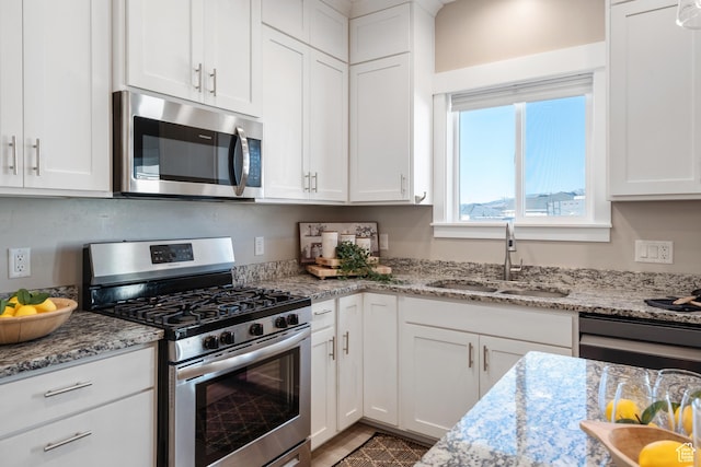 4957 N Sage Dr, Eagle Mountain, UT 84005 - kitchen featuring stainless steel appliances, a sink, white cabinets, and light stone counters