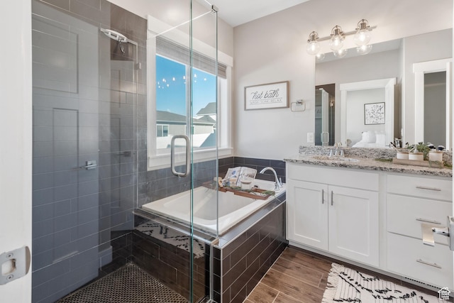 4957 N Sage Dr, Eagle Mountain, UT 84005 - full bathroom featuring a stall shower, a garden tub, vanity, and wood finished floors