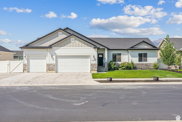 4957 N Sage Dr, Eagle Mountain, UT 84005 - view of front of property featuring a gate, an attached garage, stone siding, and driveway