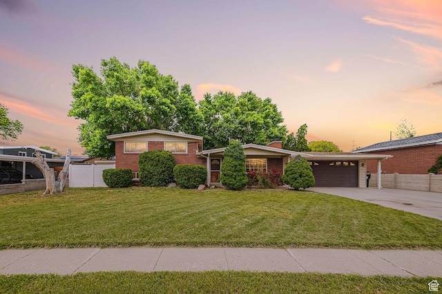 1336 W Phillips Ln S, Taylorsville, UT 84123 - split level home with concrete driveway, brick siding, an attached garage, and a chimney