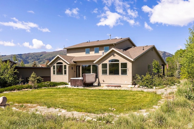 3824 N Patiosprings Dr, Eden, UT 84310 - back of house with a hot tub, stucco siding, a lawn, and a mountain view