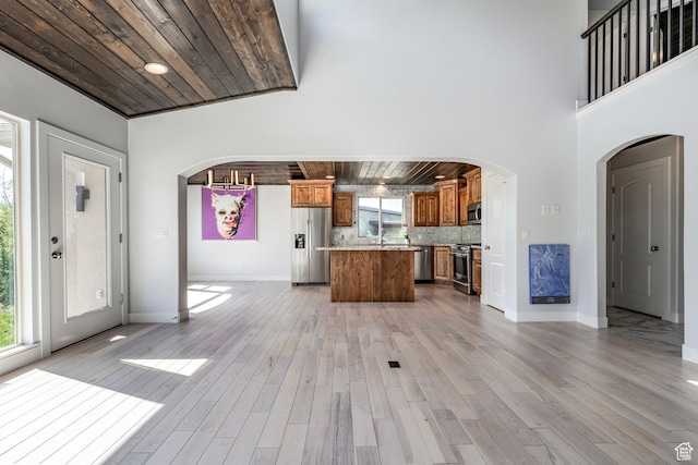 3824 N Patiosprings Dr, Eden, UT 84310 - kitchen featuring stainless steel appliances, wood ceiling, arched walkways, brown cabinetry, and a center island
