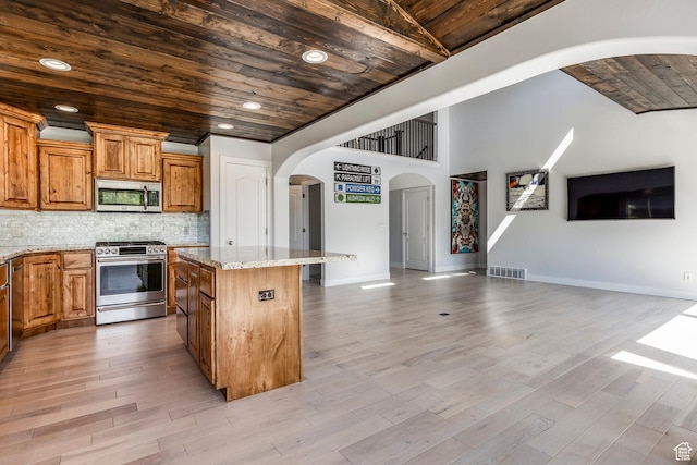3824 N Patiosprings Dr, Eden, UT 84310 - kitchen with appliances with stainless steel finishes, wooden ceiling, open floor plan, arched walkways, and a kitchen island
