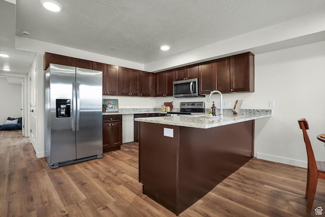 450 W Main St Unit 16, Santaquin, UT 84655 - kitchen with stainless steel appliances, a peninsula, dark brown cabinets, wood finished floors, and baseboards