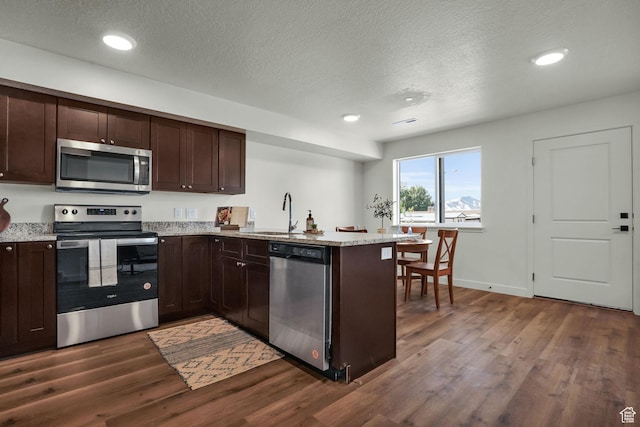 450 W Main St Unit 16, Santaquin, UT 84655 - kitchen with appliances with stainless steel finishes, a sink, dark wood-style flooring, a peninsula, and dark brown cabinetry