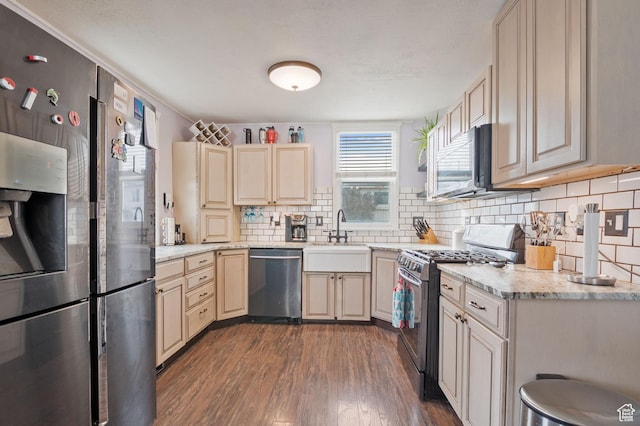 1632 W Whitlock Ave, West Valley City, UT 84119 - kitchen with appliances with stainless steel finishes, a sink, dark wood-style flooring, decorative backsplash, and cream cabinetry