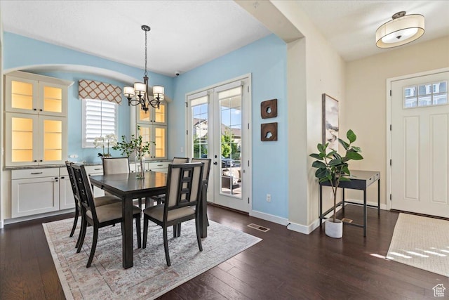 10451 S Abbott Way S, Jordan, UT 84009 - dining room featuring a chandelier, dark wood-style floors, baseboards, and arched walkways