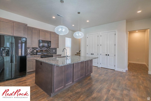 0, St. George, UT 84790 - kitchen featuring black appliances, dark wood finished floors, light stone countertops, a center island with sink, and recessed lighting