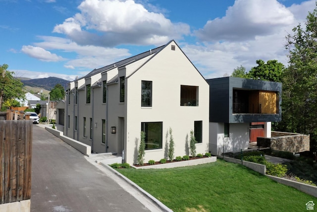520 N H St E, Salt Lake City, UT 84103 - back of house with a balcony, a lawn, a mountain view, and stucco siding