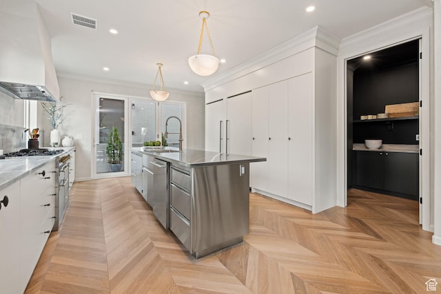 520 N H St E, Salt Lake City, UT 84103 - kitchen featuring a sink, appliances with stainless steel finishes, wall chimney range hood, white cabinets, and a center island with sink
