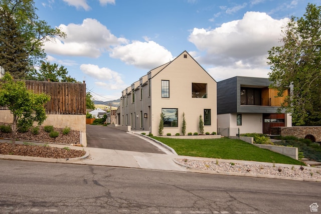 520 N H St E, Salt Lake City, UT 84103 - view of front facade featuring driveway, a front lawn, and stucco siding