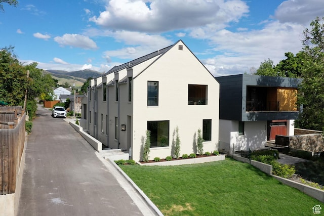 520 N H St E, Salt Lake City, UT 84103 - view of side of home featuring a yard, a mountain view, and stucco siding