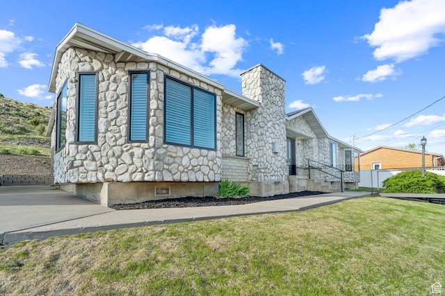 20 W Arlington Ave E, Eureka, UT 84628 - view of property exterior with a chimney, stone siding, and a yard
