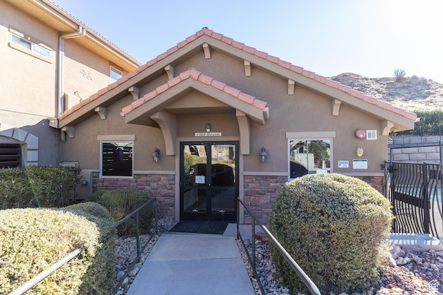 280 S Luce Del Sol Dr Unit 316, St George, UT 84770 - property entrance featuring stone siding, stucco siding, a mountain view, a tile roof, and french doors