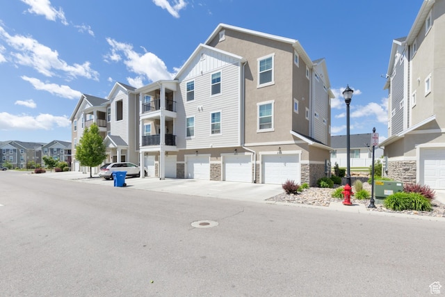 13092 S Tortola Dr Unit 101, Herriman, UT 84096 - view of front of house with a residential view, stone siding, an attached garage, and stucco siding