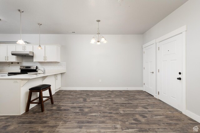 13092 S Tortola Dr Unit 101, Herriman, UT 84096 - kitchen featuring under cabinet range hood, stainless steel range with electric cooktop, a chandelier, decorative backsplash, and light countertops