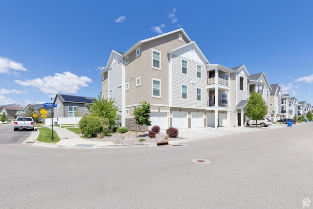 13092 S Tortola Dr Unit 101, Herriman, UT 84096 - view of building exterior with a residential view, a garage, and driveway