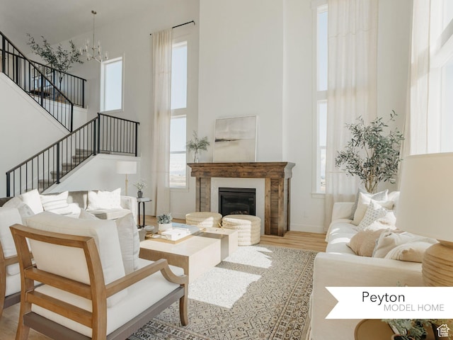 1549 W Boseman Way Unit 601, Saratoga Springs, UT 84045 - living area featuring a high ceiling, wood finished floors, stairs, a chandelier, and a glass covered fireplace