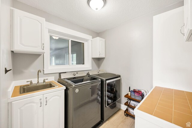 304 N 1000 E, Hyde Park, UT 84318 - laundry area with independent washer and dryer, cabinet space, light wood-style floors, and a textured ceiling